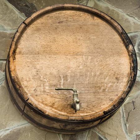Wooden wine barrel with a tap.の写真素材