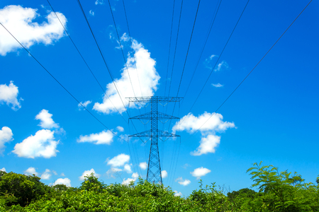 Electric high voltage tower on blue sky with white clouds background.の写真素材