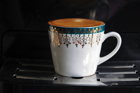 White mug with ornaments and fresh coffee.の写真素材