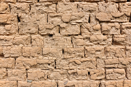 Weathered wall of a house built of bricks from clay.の写真素材