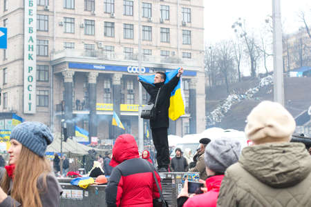 Kyiv, Ukraine - A man is holding Ukrainian flag at Maidan. Ukrainian war with Russia. High-quality photoのeditorial素材