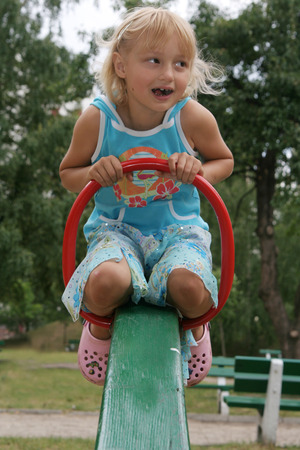 Pretty childhood girl swaying on the balance swingの写真素材