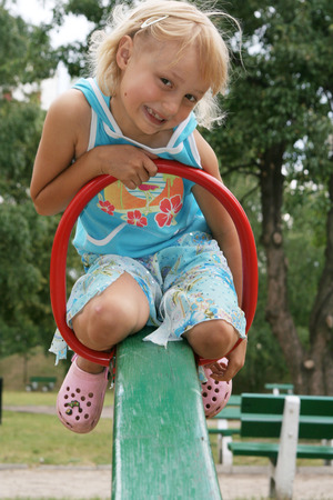  Pretty childhood girl swaying on the balance swingの写真素材