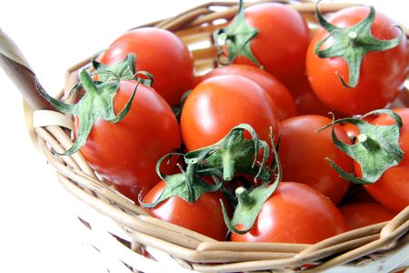 Red cherry tomatoes on a  wicker basketの写真素材