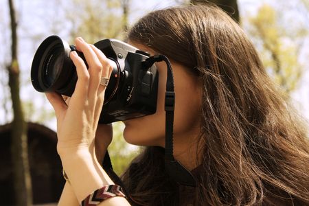 Young photographer taking a photo among the treesの写真素材