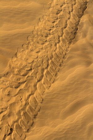 Background. Car tire track on the desert.の写真素材