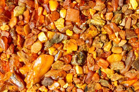 Close up. Background, texture. Orange, brown and yellow natural, raw amber stones found on the Polish cost of the Baltic Seaの写真素材