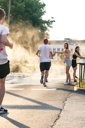 3 Rd Wizz Air Katowice Half Marathon, Katowice, Silesia, Poland. June 19, 2021. Marathon volunteer offering water needed for hydration.のeditorial素材