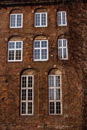 Urban architecture background. Part of the facade of a historic building with white windows. Brick wall with windows. Gdansk, Polandの写真素材