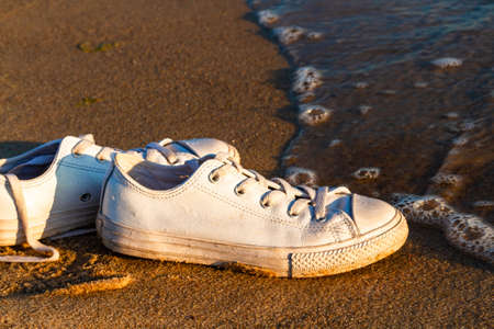 Travel and vacation concept. White sneakers on a sandy beach. Baltic Sea, Hel, Pomerania, Polandの写真素材