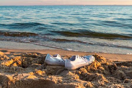 Travel and vacation concept. White sneakers on a sandy beach. Baltic Sea, Hel, Pomerania, Polandの写真素材