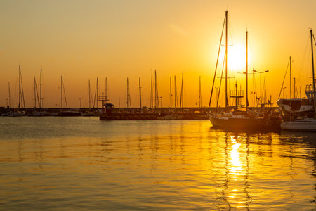 August, 27, 2022. Sailboats moored in Hel harbor. Silhouettes of masts in the light of the setting...