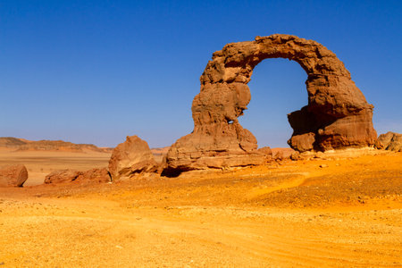 The huge, natural arch called "Arch of Tehak" in the Tadrart mountains. Tassili N'Ajjer National Park. Sahara, Algerian Desert. Illizi Province, Djanet, Algeria, Africaの写真素材