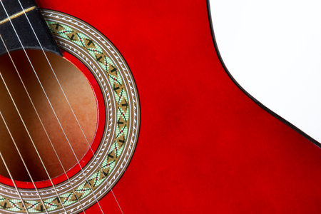 Close-up. A part of a red acoustic guitar on a white backgroundの写真素材