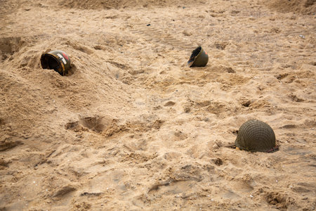 Three American infantry helmets M1 from the Second World War on the beach.の写真素材
