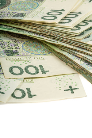 A large stack of Polish 100 zloty banknotes on a white background. Synonymous with wealth and...