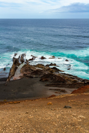 A litte black sandy beach Playa de los Clicos in El Golfo bay. Atlantic ocean, Lanzarote, Canary...