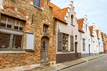 Street in Bruges. Typical colorful townhouses with pyramidal facade and street paved with cobblestones. Bruges, Belgium, Europeの写真素材