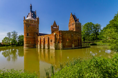 Beersel Castle. The walls and towers of the medieval castle reflected in the moat on a beautiful sunny day. Beersel castle, Flanders, Belgiumの写真素材