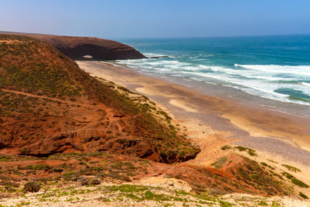 Red rocks with a natural arch on the coast of the Atlantic Ocean. Legzira beach (or Lagzira, or Gzira). Sidi Ifni, Morocco, Africaの写真素材