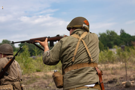 Historical reenactment. American soldier during the WWII. Infantry soldier preparing for shooting.