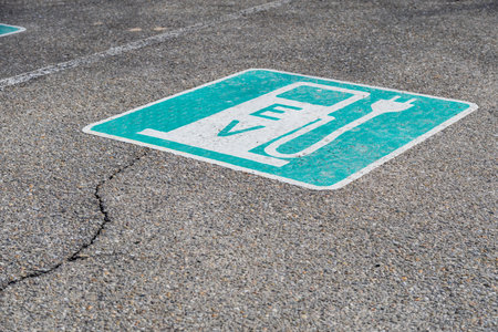 A typical electric vehicle charging station sign painted on a parking space. E-mobility concept....