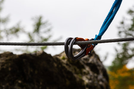 Double carabiner attached to a steel safety rope during climbing.の写真素材