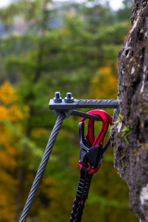 Double carabiner attached to a steel safety rope during climbing.の写真素材