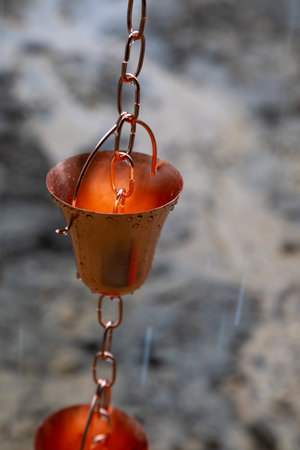 Close-up. Gutter chain. Decorative rainwater collector on a rainy day.