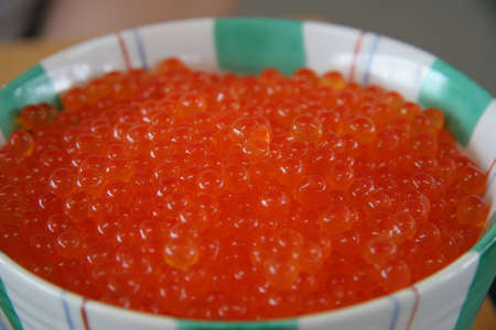 Bowl of orange ikura (salmon fish row, a Japanese delicacy) in a bowl of riceの写真素材