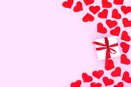 Background with gift and hearts with free space for text on pastel pink background. Flat lay, top view. Valentines day concept. Mother's Day concept.の写真素材