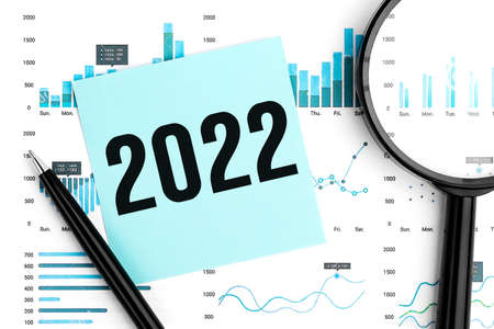Word 2022 on sticker. Magnifier, pen and charts and graphs top view. Business and statistical concept on white background.の写真素材