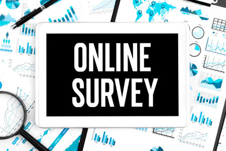 Text ONLINE SURVEY on tablet. Pen, magnifier and graphs. Business concept. Flat lay.の写真素材