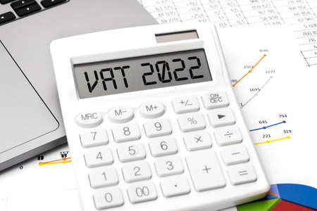 Text VAT 2022 - Value - Added Tax on calculator, laptop, chatrs, graphs. Business flat lay.の写真素材
