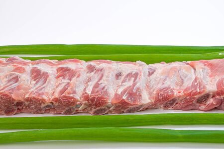 meat on ribs with green onions on a white backgroundの写真素材