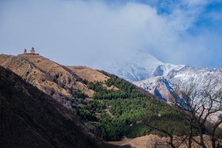 Tsminda Sameba church and Kazbek mountain in clouds, Georgia