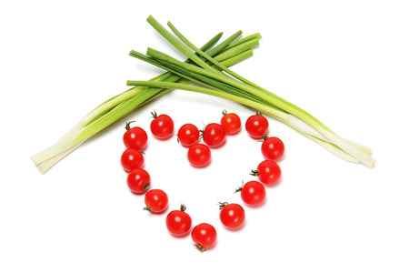 Heart Tomato pierced with an arrow. The composition of vegetables.の写真素材