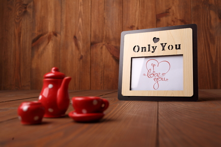 Romantic theme on a chalkboard behind a wooden table with cup of coffee. Toned.の写真素材
