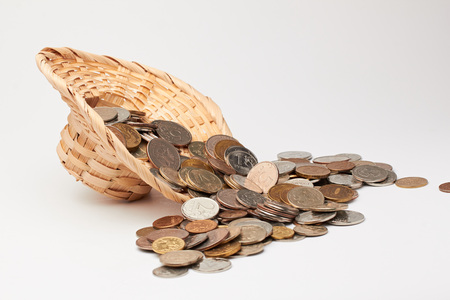 Wicker hat with coins on white background.の写真素材