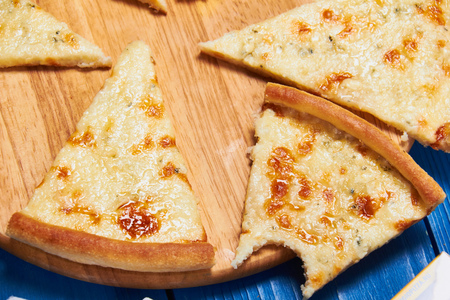 Pizza with three cheeses on a wooden board blue.の写真素材