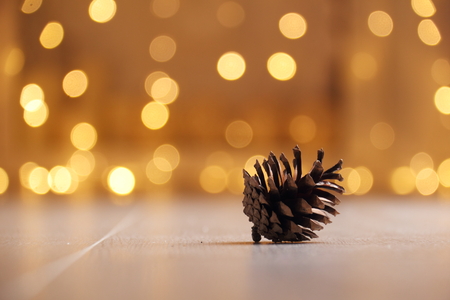 Cone spruce and garland. Cone spruce lies against the backdrop of Christmas light.の写真素材