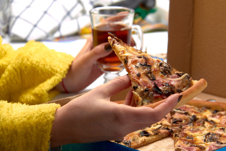 Pizza and slice of pizza in hand.の写真素材