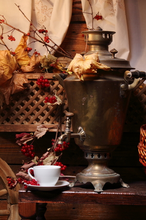 Samovar with a cup of tea. / Cup of tea and a Russian samovar under the light of a lantern. Autumn.の写真素材