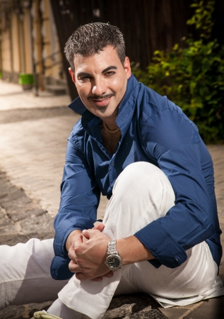 Portrait of handsome man sitting on roadの写真素材