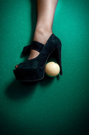 White billiard ball stuck in high heel black shoeの写真素材