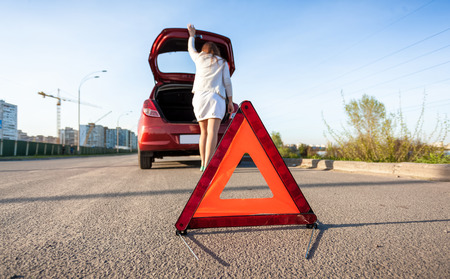 Photo of woman looking in trunk of broken carの写真素材