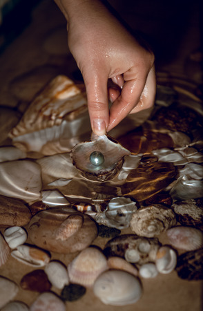 Closeup photo of woman searching for pearls at nightの写真素材