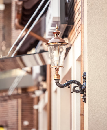 Closeup photo of street lamp on building stylized to retro gas lampの写真素材