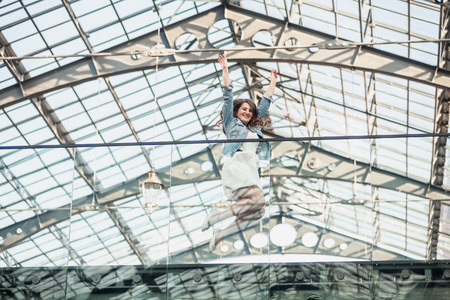 Beautiful happy woman jumping up high at airportの写真素材