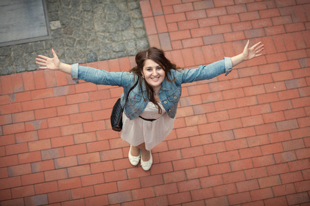 View from high point of young smiling woman stretching out handsの写真素材